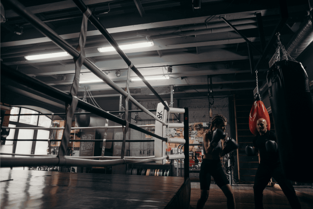 Area di allenamento per Kickboxing e sport da combattimento con ring e atleti al lavoro